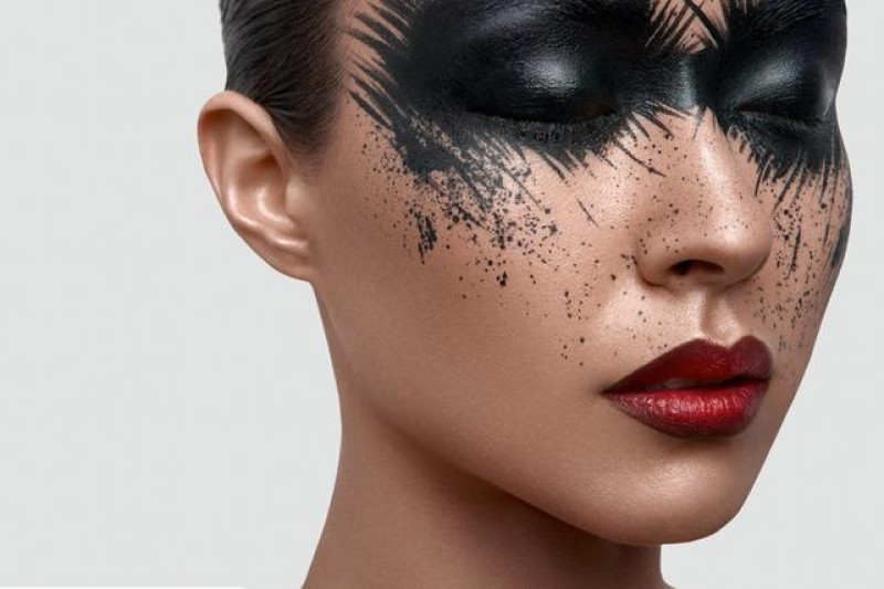 Beauty Model with black Paint Stains on Face