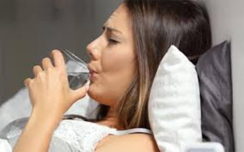 γυναίκα στο κρεβάτι πίνει νερό εμμηνόπαυση 