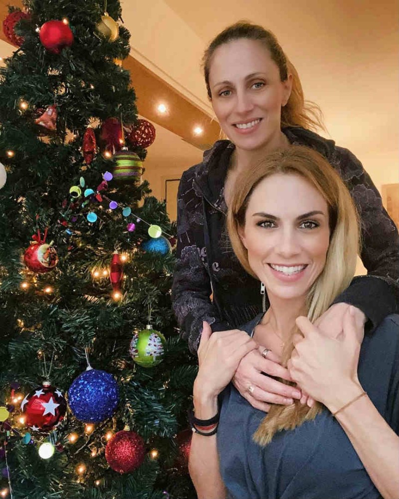 Η Ντορέττα Παπαδημητρίου ποζάρει μπροστά από το χριστουγεννιάτικο δέντρο αγκαλιά με την αδερφή της