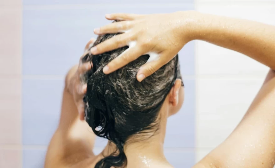 γυναίκα λούζει τα μαλλιά της