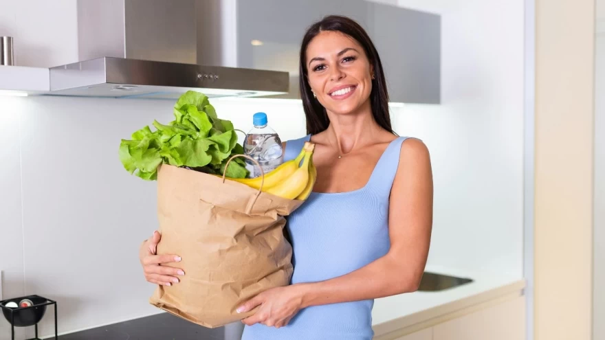 γυναίκα που κρατά σακούλα με φρούτα και λαχανικά