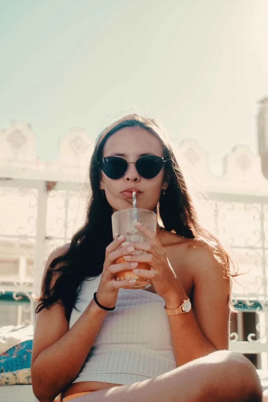 κοπέλα με γυαλιά πίνει χυμό