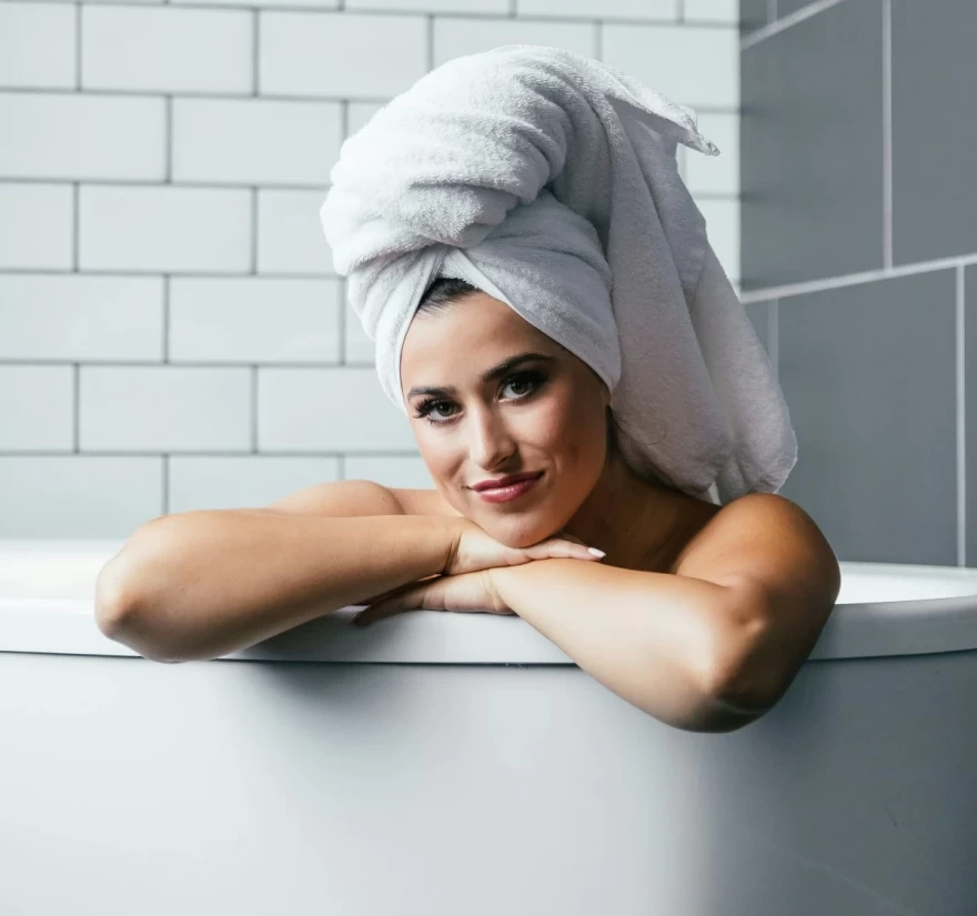 γυναίκα στο μπάνιο με πετσέτα στο κεφάλι
