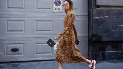 Γυναίκα φοράει λεοπάρ φόρεμα και σουέτ αθλητικά παπούτσια