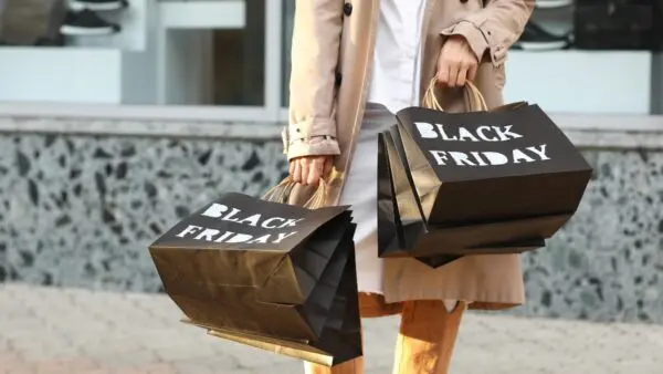 μια γυναίκα με σακούλες που γράφουν πάνω black friday
