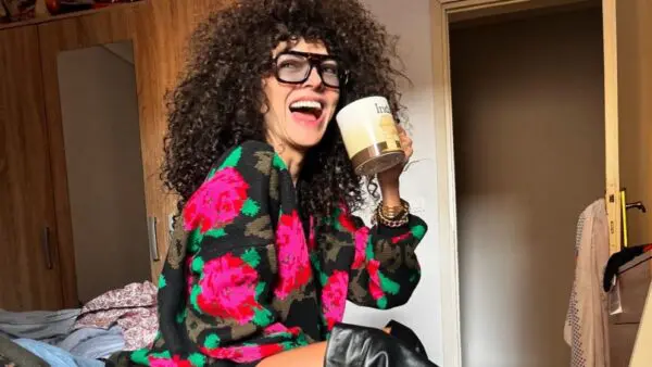 Η μαρία Σολωμού με φλοράλ πουλόβερ και καφέ στο χέρι