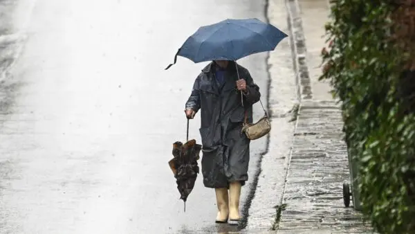 Γυναίκα περπατάει μέσα στην βροχή