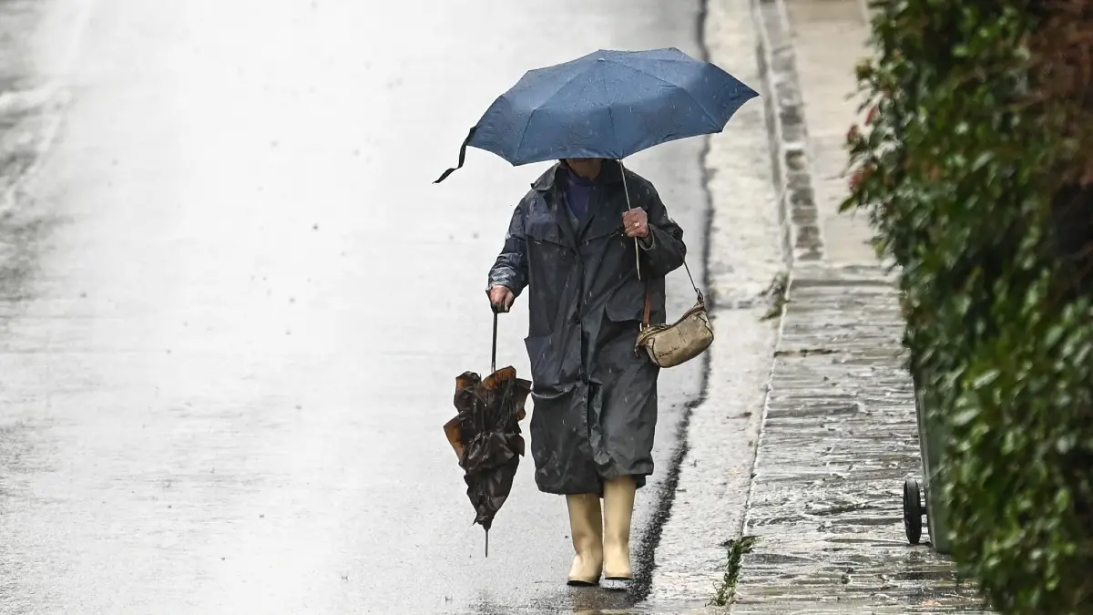 Γυναίκα περπατάει μέσα στην βροχή