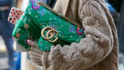 Με πουλόβερ και εμπριμέ τσάντα γυναίκα στον δρόμο