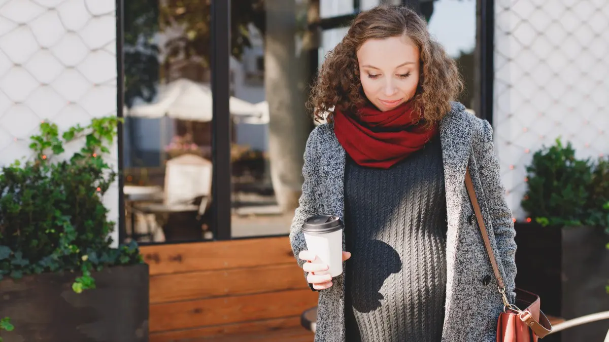 Έγκυος κοπέλα περπατάει στον δρόμο