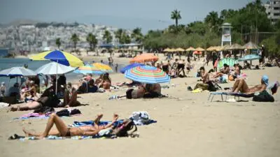 κόσμος κάνει μπάνιο σε παραλία