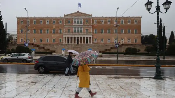 μια γυναίκα με ομπρέλα στην βροχή Αθήνα