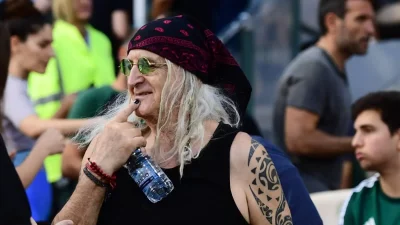 Όλα τα βλέμματα έπεσαν πάνω του: Με αμάνικο, μπαντάνα και μαύρο νύχι στο γήπεδο ο Καρβέλας μαζί με την σύντροφό του