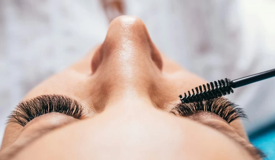 γυναίκα εφαρμόζει μάσκαρα στα βλέφαρα