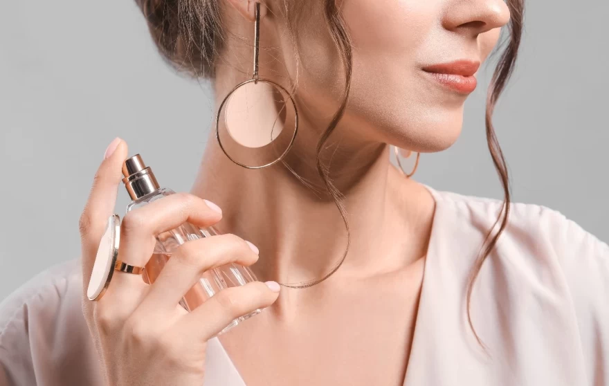 γυναίκα ψεκάζει άρωμα στο λαιμό της