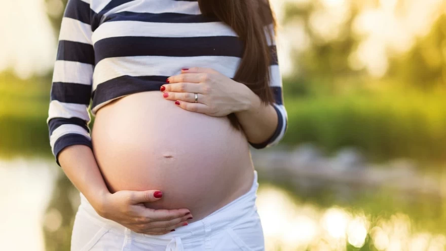 έγκυος γυναίκα ακουμπά την κοιλιά της