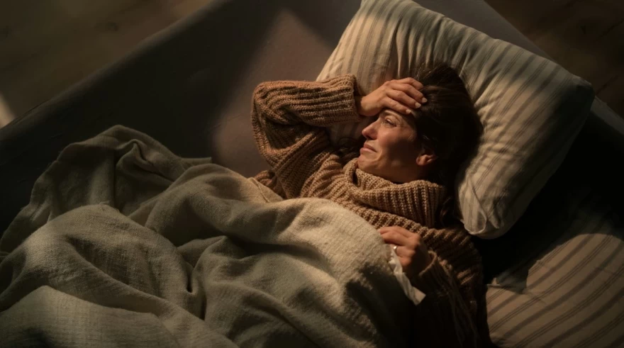 γυναίκα αγχωμένη πάνω στο κρεβάτι