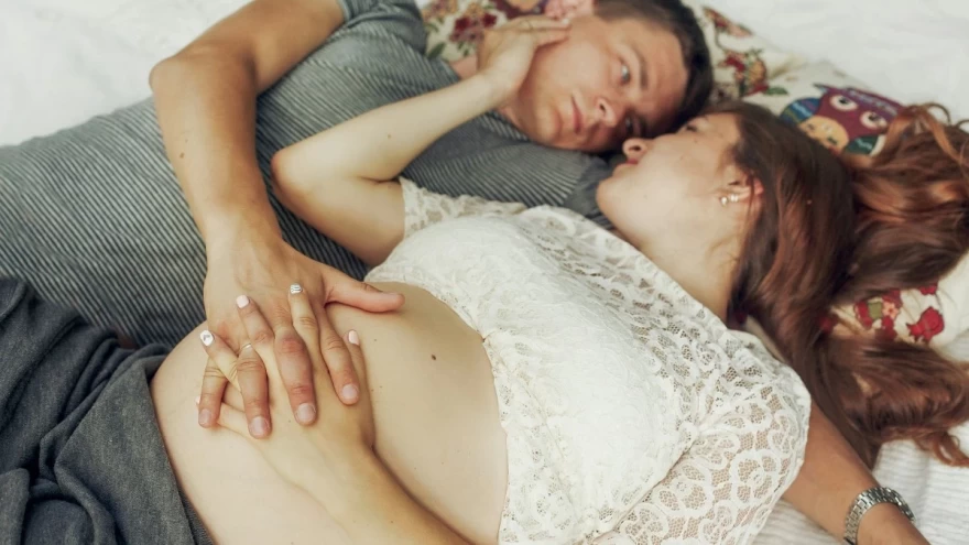 έγκυος στο κρεβάτι με το σύντροφό της