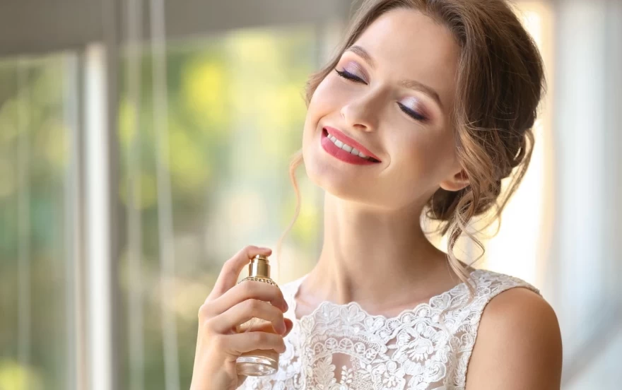 γυναίκα ψεκάζει άρωμα πάνω στο σώμα της