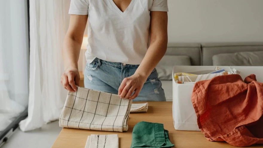 γυναίκα διπλώνει πετσέτες στο σπίτι