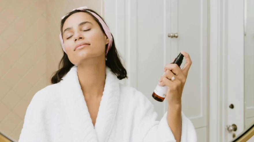 γυναίκα ψεκάζει το πρόσωπό της με σπρέι