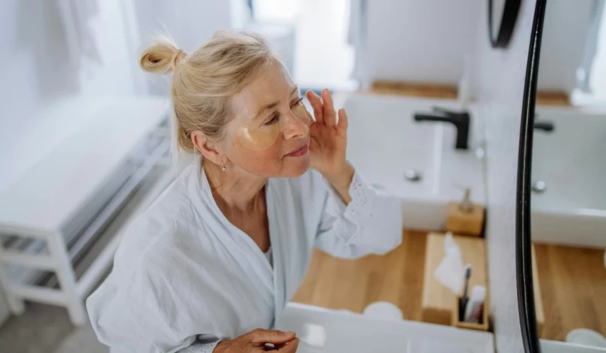 γυναίκα εφαρμόζει μάσκα μπροστά στον καθρέπτη