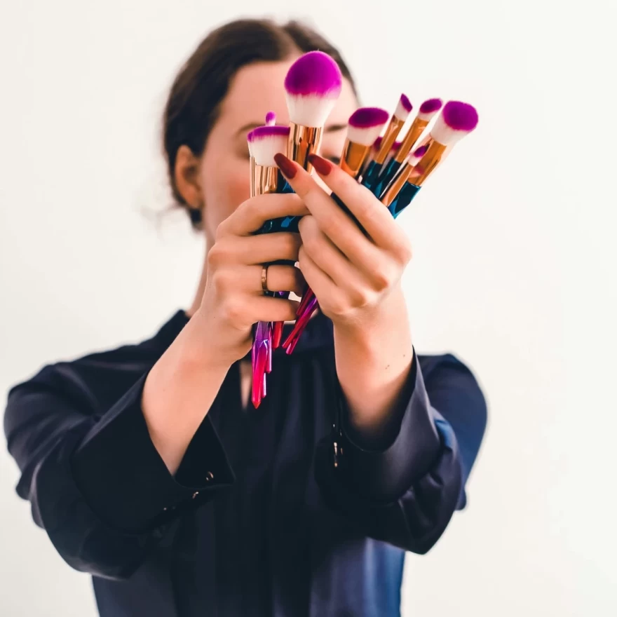 γυναίκα κρατά πινέλα μακιγιάζ