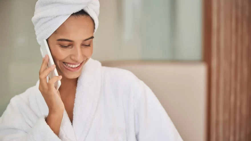 γυναίκα με μπουρνούζι μιλά στο κινητό