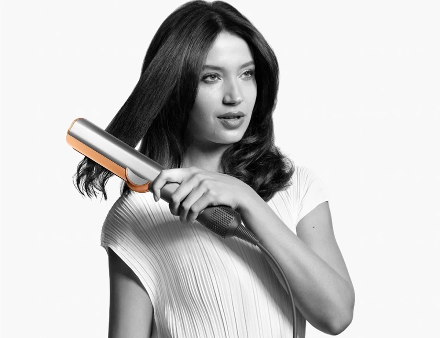 γυναίκα ισιώνει τα μαλλιά της με το Dyson Αirstrait