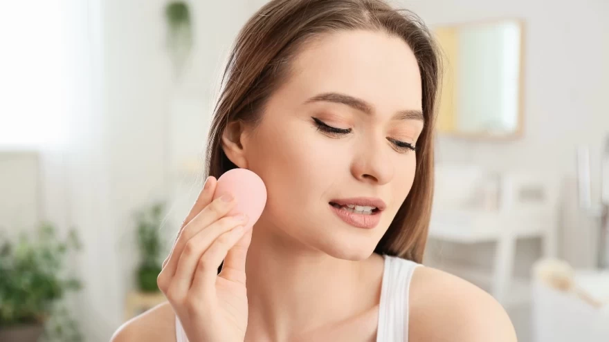 γυναίκα εφαρμόζει makeup με σφουγγαράκι μακιγιάζ