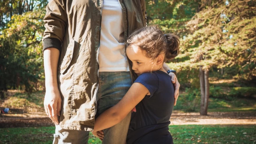 ντροπαλό κορίτσι αγκαλιάζει τη μαμά του