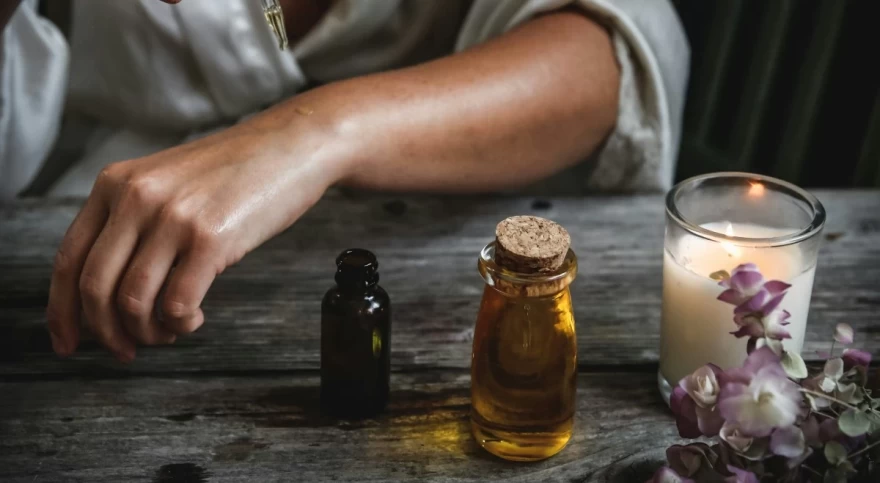 γυναίκα εφαρμόζει έλαιο στο δέρμα της