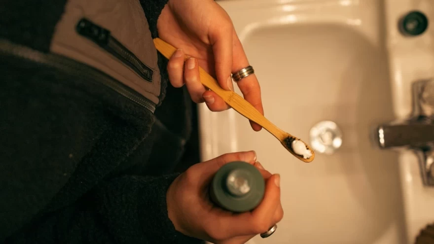 γυναίκα απλώνει οδοντόκρεμα σε οδοντόβουρτσα