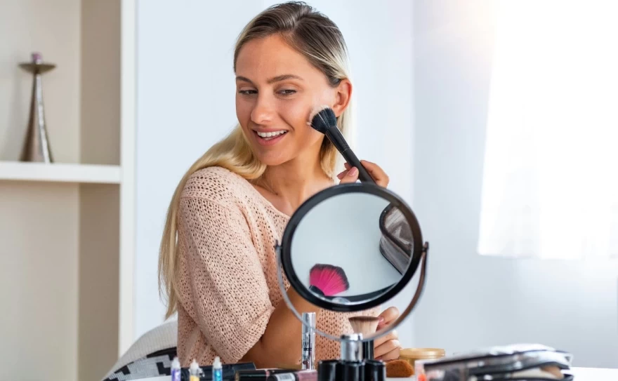 γυναίκα εφαρμόζει ρουζ στο πρόσωπο