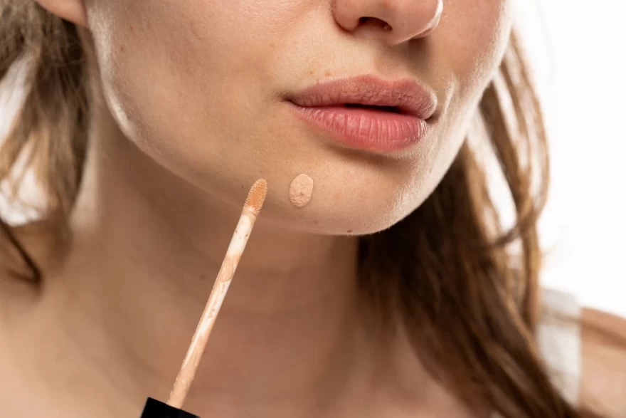 γυναίκα εφαρμόζει concealer πάνω σε σπυράκι