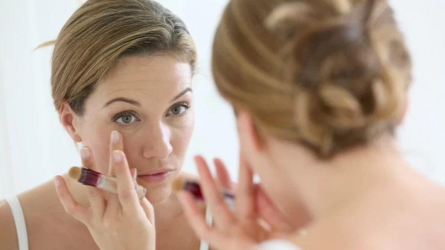 γυναίκα εφαρμόζει concealer