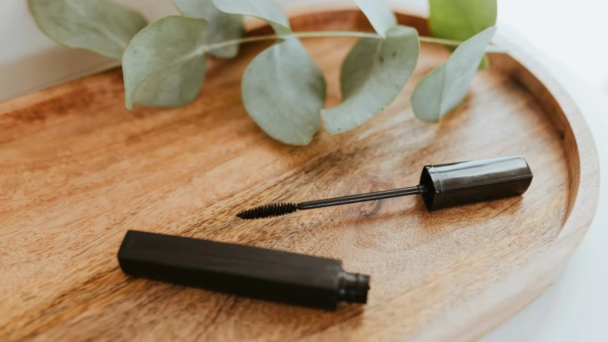ανοιχτή μαύρη μάσκαρα πάνω σε τραπέζι