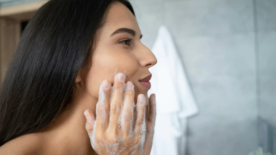 γυναίκα καθαρίζει το πρόσωπό της με σαπούνι