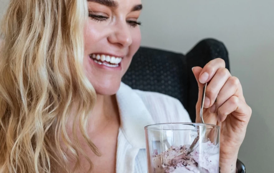 ώριμη γυναίκα τρώει γλυκό μέσα σε ποτήρι