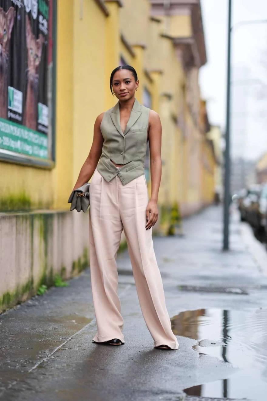 γυναίκα με μπεζ γιλέκο και ροζ παντελόνι