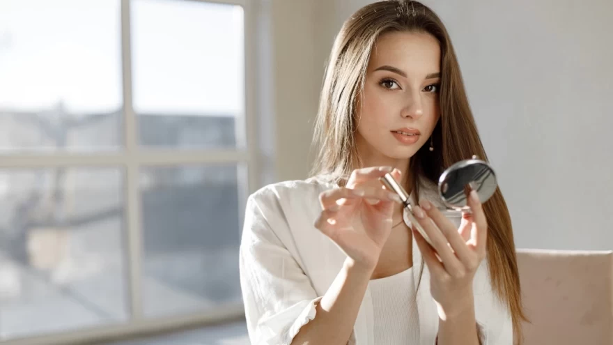 γυναίκα κρατάει μάσκαρα και μακιγιάρεται