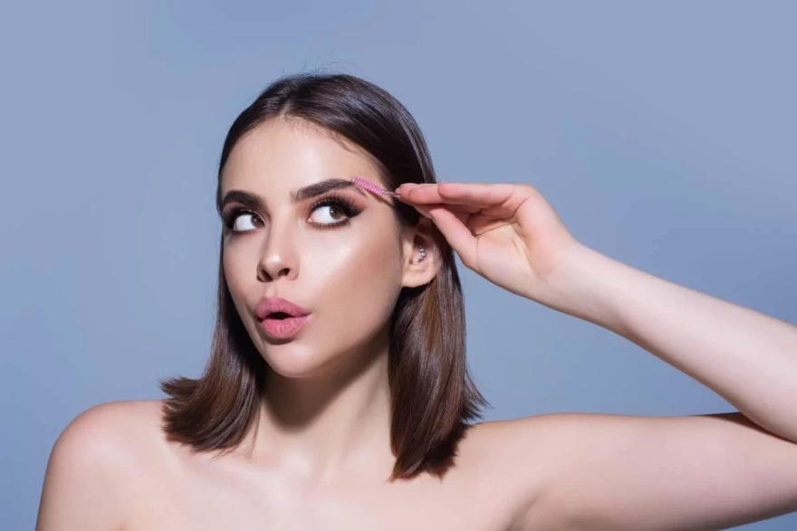 κοπέλα φτιάχνει τα φρύδια της