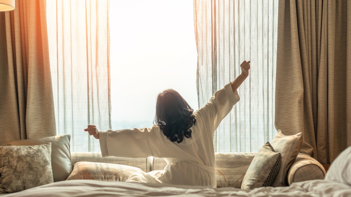 γυναίκα ξυπνάει το πρωί στο υπνοδωμάτιο