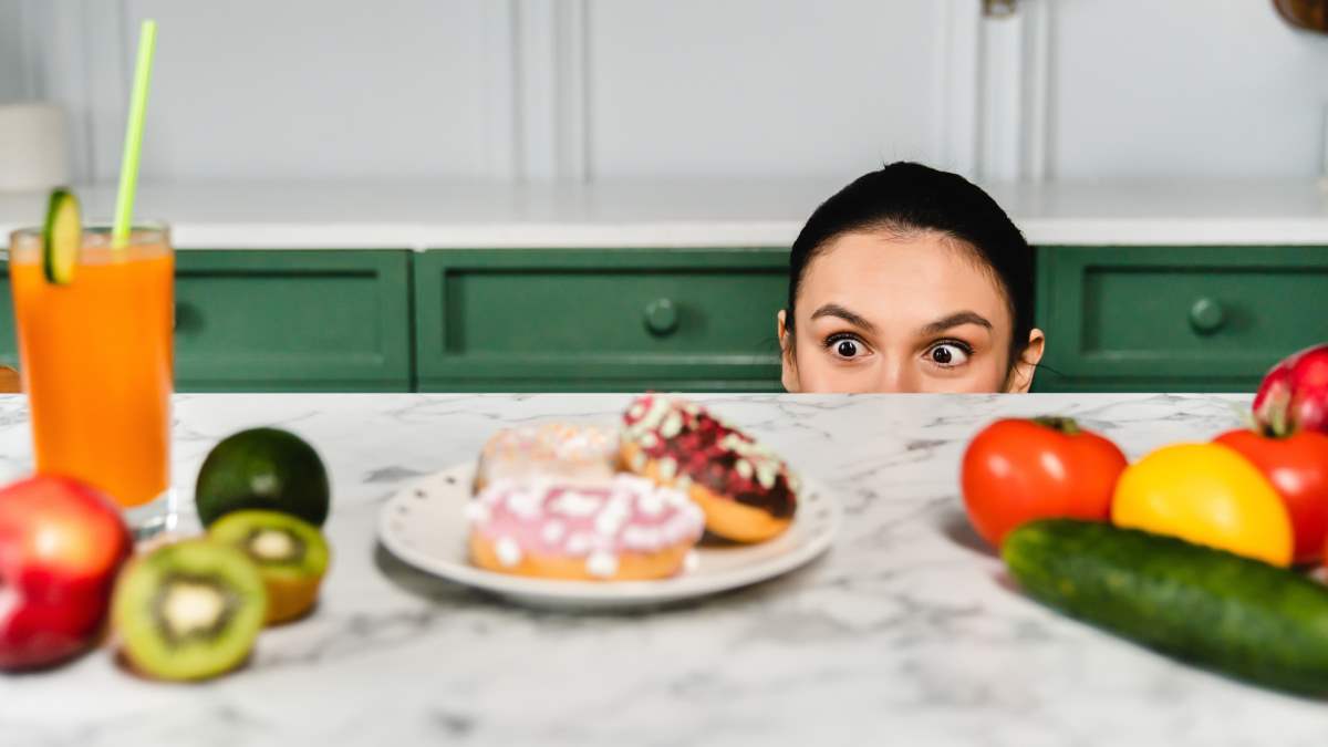 γυναίκα κοιτάζει πιάτο με γλυκά