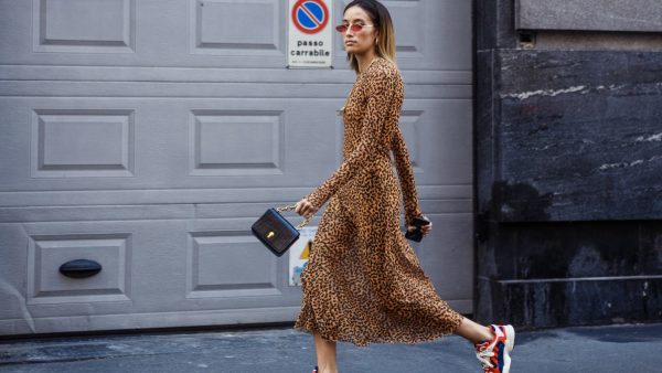 Γυναίκα φοράει λεοπάρ φόρεμα και σουέτ αθλητικά παπούτσια