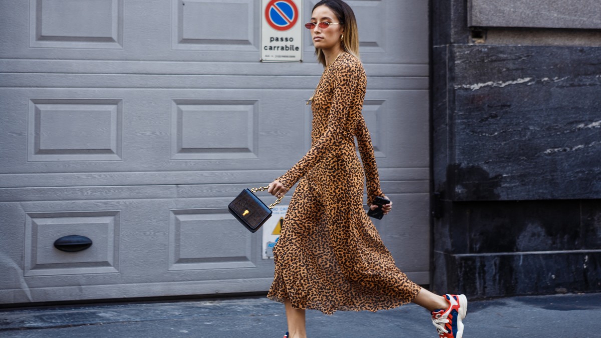 Γυναίκα φοράει λεοπάρ φόρεμα και σουέτ αθλητικά παπούτσια