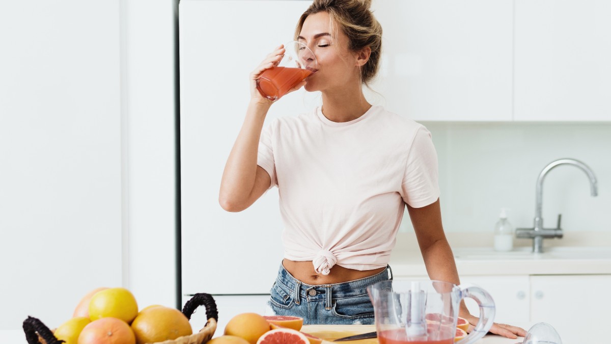 γυναίκα πίνει χυμό που μειώνει το λίπος της κοιλιάς