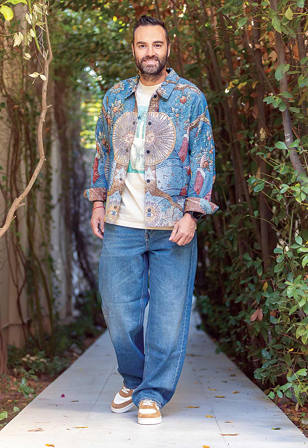 Ο Κώστας Φραγκολιάς με overshirt και t-shirt με στάμπα, Scotch & Soda, τζιν παντελόνι, Diesel και sneakers