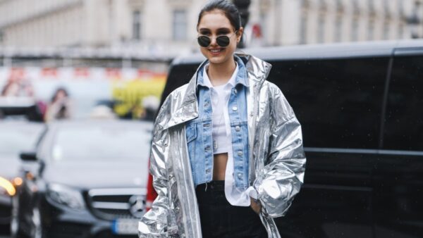 Μοντέλο με τζιν και ασημί πανωφόρι στον δρόμο