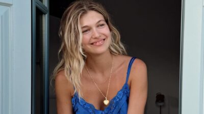 H Κλέλια Ανδριολάτου με μπλε φόρεμα μπροστά σε παράθυρο